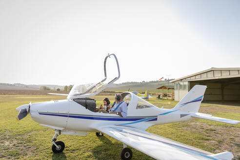 Enkelin und Großvater bereiten sich auf den Start eines Flugzeugs auf dem Flugplatz vor - EIF00213