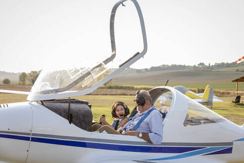 Kleines Mädchen und Großvater machen sich bereit, ein Flugzeug auf dem Flugplatz zu starten - EIF00214
