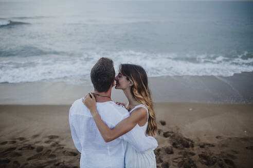 Freundin küsst ihren Freund, während sie am Strand steht - GMLF00675
