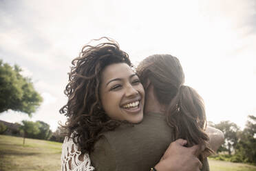 Couple embracing while standing at public park - AJOF00138