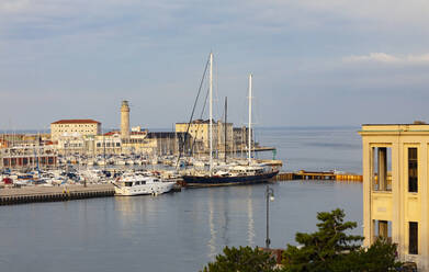 Italien, Friaul-Julisch Venetien, Triest, Boote im Yachthafen San Giusto Sea Center mit dem Leuchtturm La Lanterna im Hintergrund - WWF05438