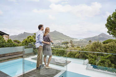 Couple standing while looking at view from balcony of modern house - RORF02347