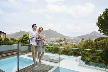 Couple holding wine glass while standing in balcony - RORF02349