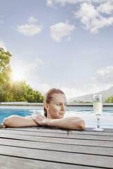 Young woman looking away while lying in pool - RORF02404