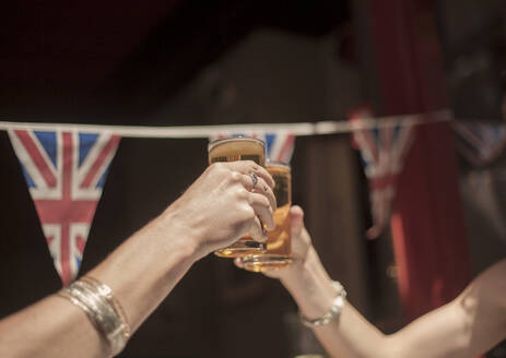 Weibliche Freunde stoßen mit Biergläsern an, während sie das Wochenende im Pub genießen - AJOF00162