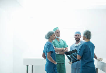 Weibliche und männliche Chirurgen diskutieren über medizinische Röntgenaufnahmen im Krankenhaus - AJOF00207