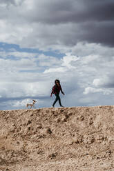 Spanien, Navarra, Junge Frau beim Wandern mit Hund in Bardenas Reales - EBBF00833