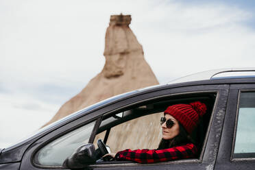 Young woman sitting inside car in Bardenas Reales - EBBF00837