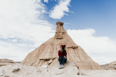 Spanien, Navarra, Touristin vor Sandsteinfelsen in Bardenas Reales sitzend - EBBF00846