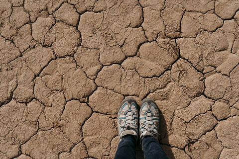 Spain, Navarre, Shoes of woman standing on dry cracked ground of Bardenas Reales stock photo