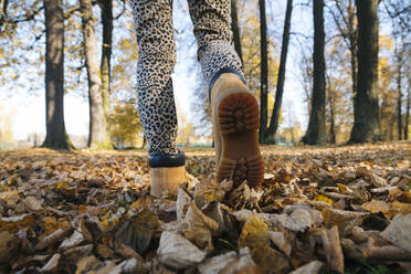 Füße einer Frau, die in einem öffentlichen Park spazieren geht - KNTF05697
