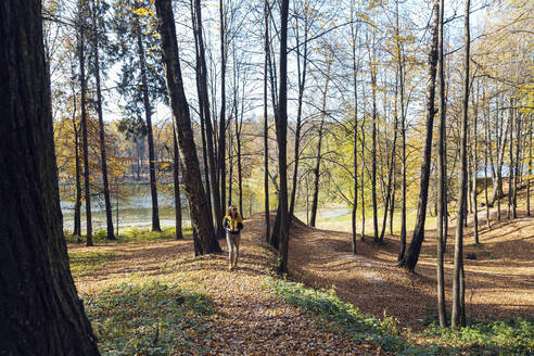 Mittlere erwachsene Frau erkundet öffentlichen Park an einem sonnigen Tag - KNTF05699