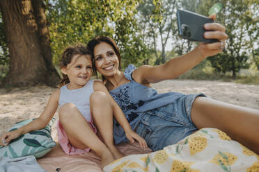 Mutter und Tochter machen ein Selfie mit dem Smartphone am Strand - MFF06233