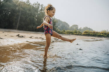 Nettes kleines Mädchen spielt im Wasser am Strand an einem sonnigen Tag - MFF06253