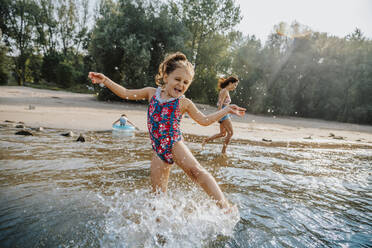 Mutter und Töchter vergnügen sich im Wasser am Strand an einem sonnigen Tag - MFF06257