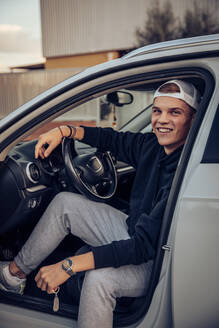 Lächelnder junger Mann im Auto sitzend - ACPF00817