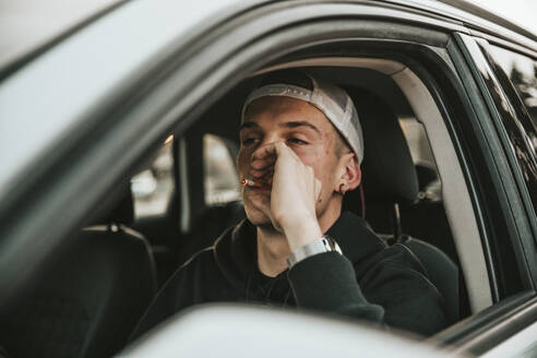 Junger Mann raucht Zigarette beim Autofahren - ACPF00820