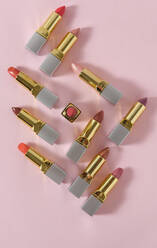 High angle of luxury lipsticks of various colors placed on pink background in studio - ADSF16606