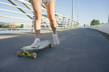 Legs of woman skating on street during sunny day - VPIF03156