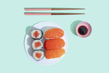Studioaufnahme von Essstäbchen, Schüssel mit Sojasauce und Teller mit Maki-Sushi und Nigiri - GEMF04226