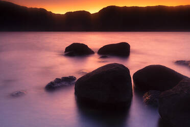Boulders on shore of Sanabria Lake at dusk - DSGF02254