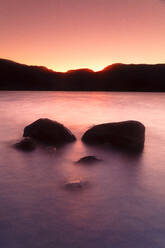 Boulders on shore of Sanabria Lake at dusk - DSGF02255