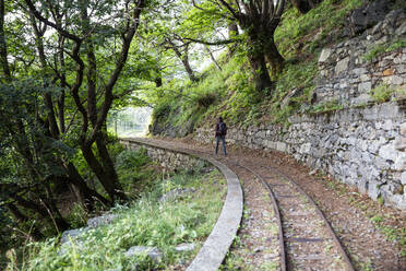 Mann wandert entlang der Tracciolino-Eisenbahnstrecke - MAMF01354