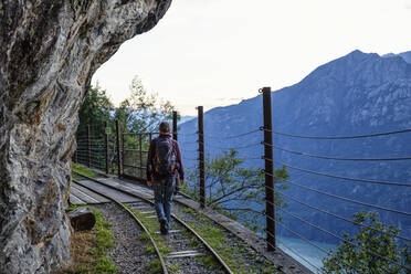 Man hiking along Tracciolino railroad track at dusk - MAMF01357