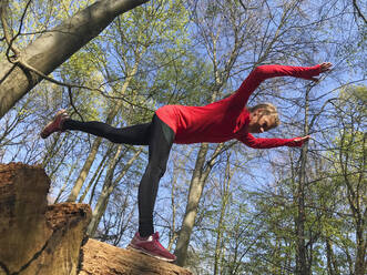 Woman controlling balance while exercising at park - GWF06764