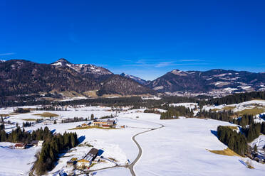 Austria, Tyrol, Kossen, Helicopter view of mountain village in snow-covered Leukental valley - AMF08558