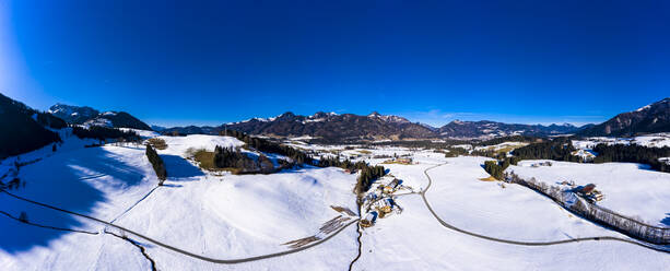 Austria, Tyrol, Kossen, Helicopter panorama of mountain village in snow-covered Leukental valley - AMF08560