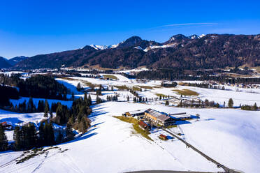Austria, Tyrol, Kossen, Helicopter view of mountain village in snow-covered Leukental valley - AMF08563