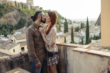 Couple kissing while standing on rooftop - JSMF01883