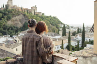 Mann und Frau bewundern die Aussicht, während sie auf dem Dach stehen - JSMF01884