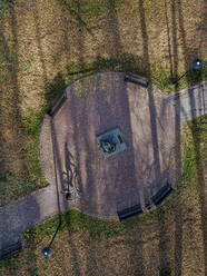 Russland, Moskauer Gebiet, Sergijew Posad, Luftaufnahme einer Radfahrerin, die am Denkmal für Michail Prischwin im Herbstpark vorbeifährt - KNTF05723