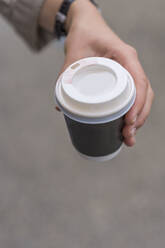 Hand einer Frau, die einen Einweg-Kaffeebecher hält - BOYF01622