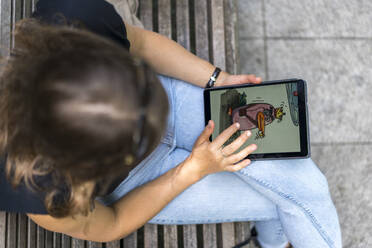 Young woman drawing on graphic tablet while sitting in public park - BOYF01640