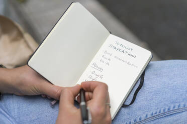 Close-up of woman writing in note pad - BOYF01643