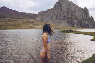 Junge Frau im Bikini, stehend im See der Ibonen von Anayet - RSGF00354