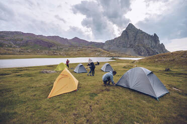 Friends preparing camp by lake at Ibones of Anayet - RSGF00358