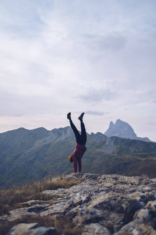 Junger Mann macht Handstand auf dem Berg um Ibones von Anayet, lizenzfreies Stockfoto