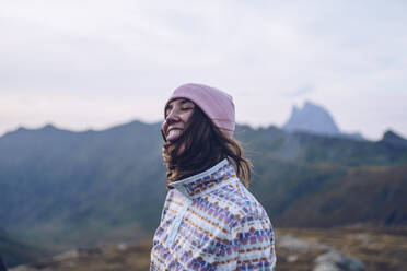 Lächelnde Frau mit Strickmütze auf einem Berg in der Nähe von Ibones of Anayet - RSGF00364