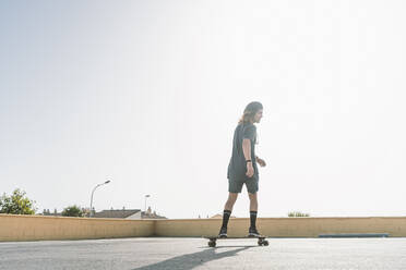 Young man skating with roller skate on rooftop in city - DAMF00554