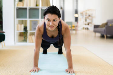 Young woman doing push ups at home - GIOF09151