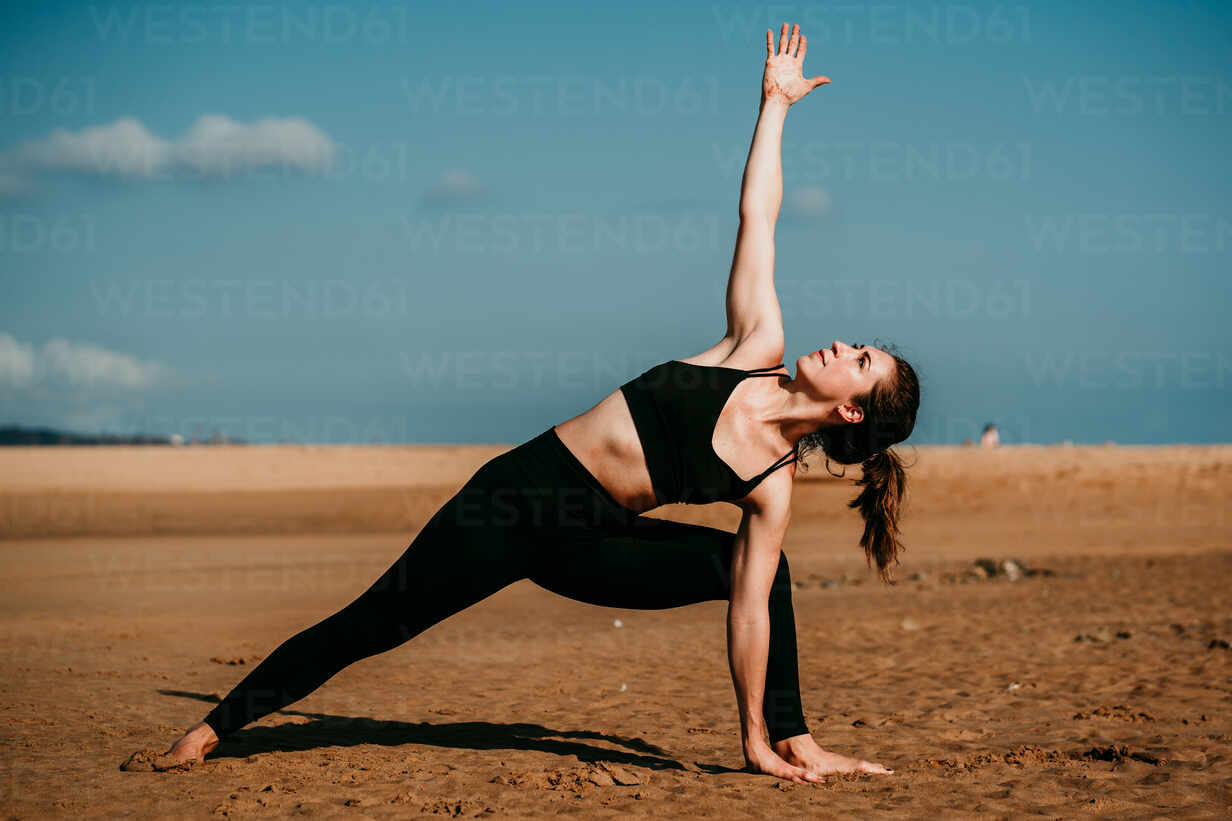 Premium Photo | Side portrait of young beautiful woman in yoga pose at the  beach