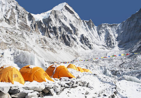 Eine Gruppe orangefarbener Zelte in einem Bergsteiger-Basislager in der Himalaya-Region. - MINF15200