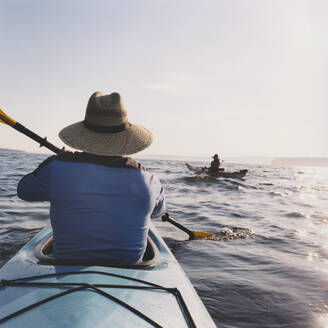 Mann und Frau mittleren Alters beim Seekajakfahren. - MINF15213