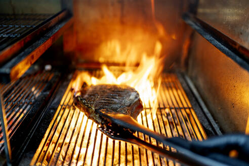 Fleisch wird auf dem Grill im Restaurant gebraten - OCMF01756