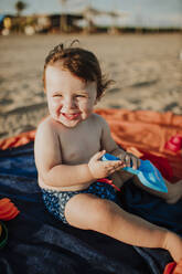 Männliches Kleinkind genießt das Spielen an einem sonnigen Tag am Strand - GMLF00732