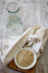 Ingredients for making rice milk - bottle of water, fabric and bowl of brown rice - EVGF03839